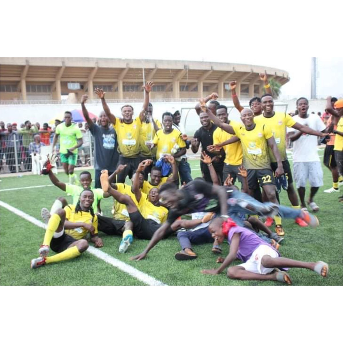 Watanga FC players and supporters celebrating on the pitch